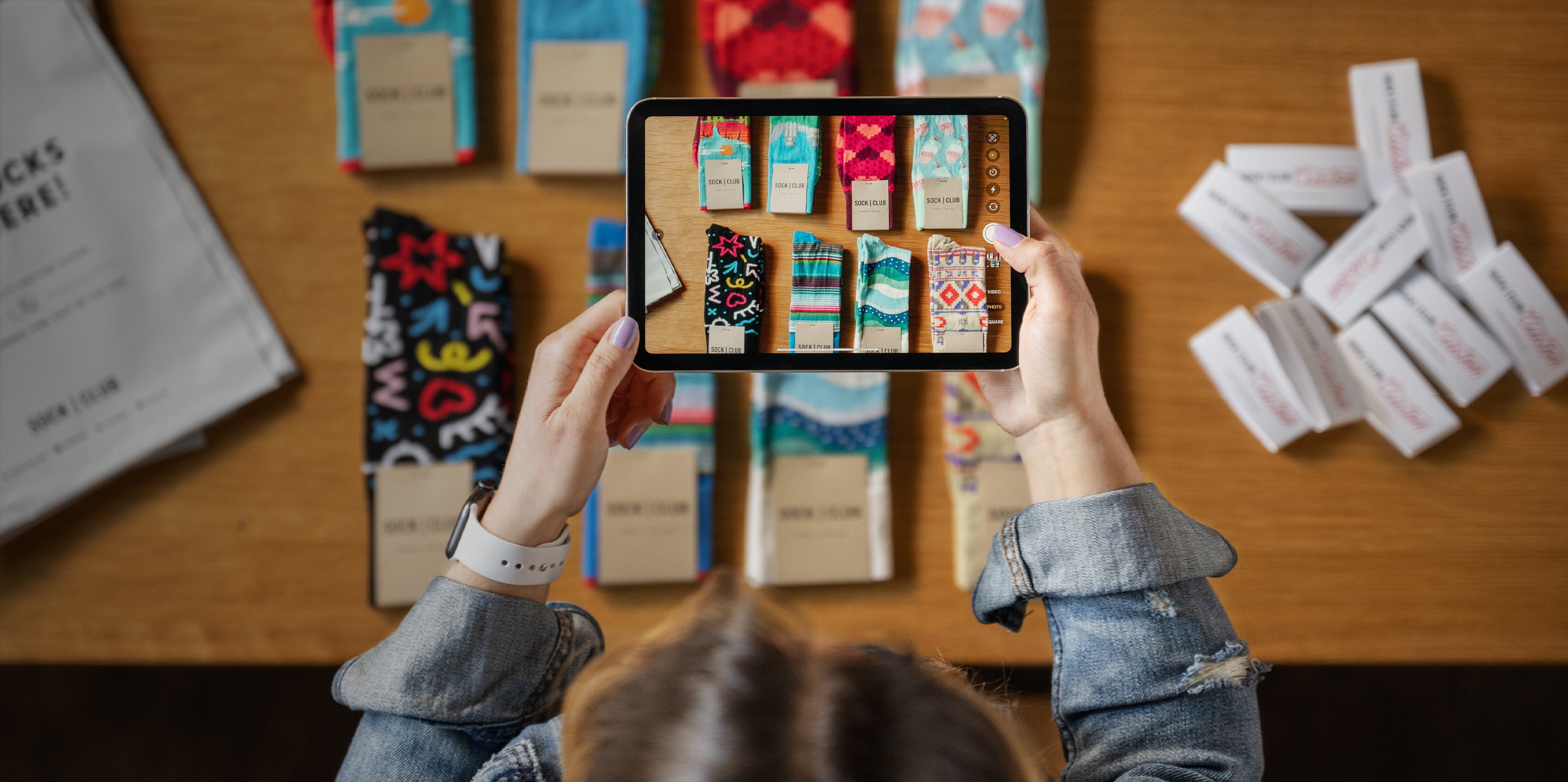 Donna che inquadra calze di vari colori con un iPad